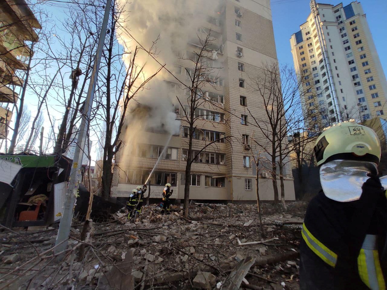 Fire fighters work on a building recently shelled by Russian forces